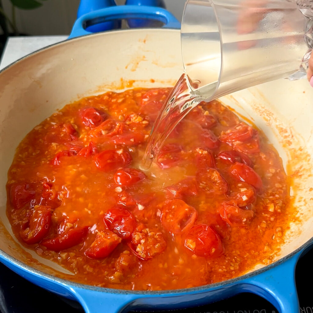 Pour in the white wine and let it simmer for about 5 minutes. Scrape the pan a little. Add chili flakes and tomato paste, then stir until everything looks evenly red and cozy