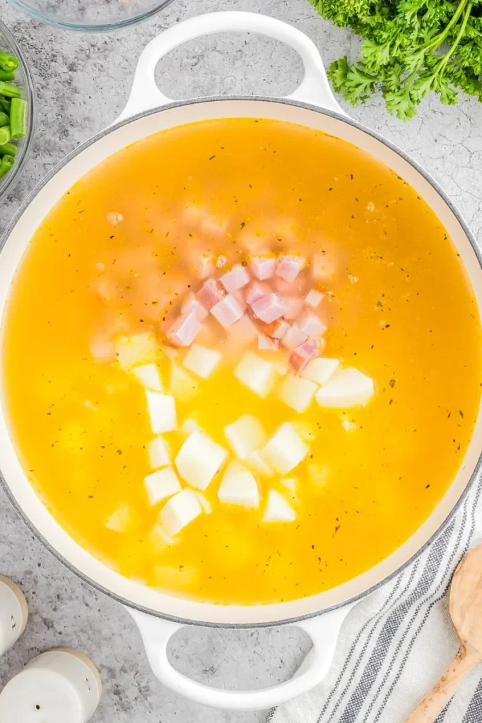 Add the ham, potatoes, and broth.