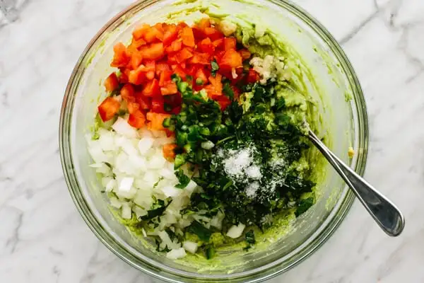 Add the onion, tomatoes, cilantro, jalapeño, garlic, lime juice, and salt to the bowl