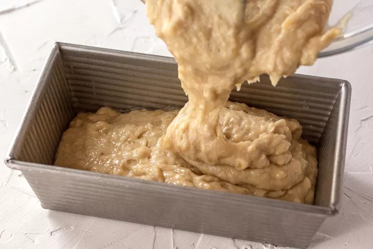 Pour the batter into your greased loaf pan. It’ll be thick. Plop it in