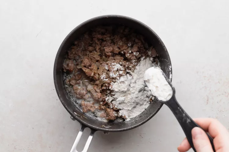 Return sausage to the pan, sprinkle with flour, and cook until lightly golden and bubbling