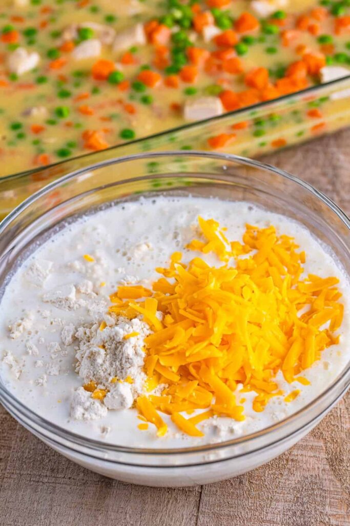 In another bowl, combine the biscuit mix, milk, and shredded cheddar cheese. Stir until well mixed. Do not add the seasoning packet yet