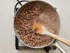 Cook the ground beef in a large skillet over medium-high heat until browned, breaking it into small pieces as it cooks. Drain off any excess grease.
