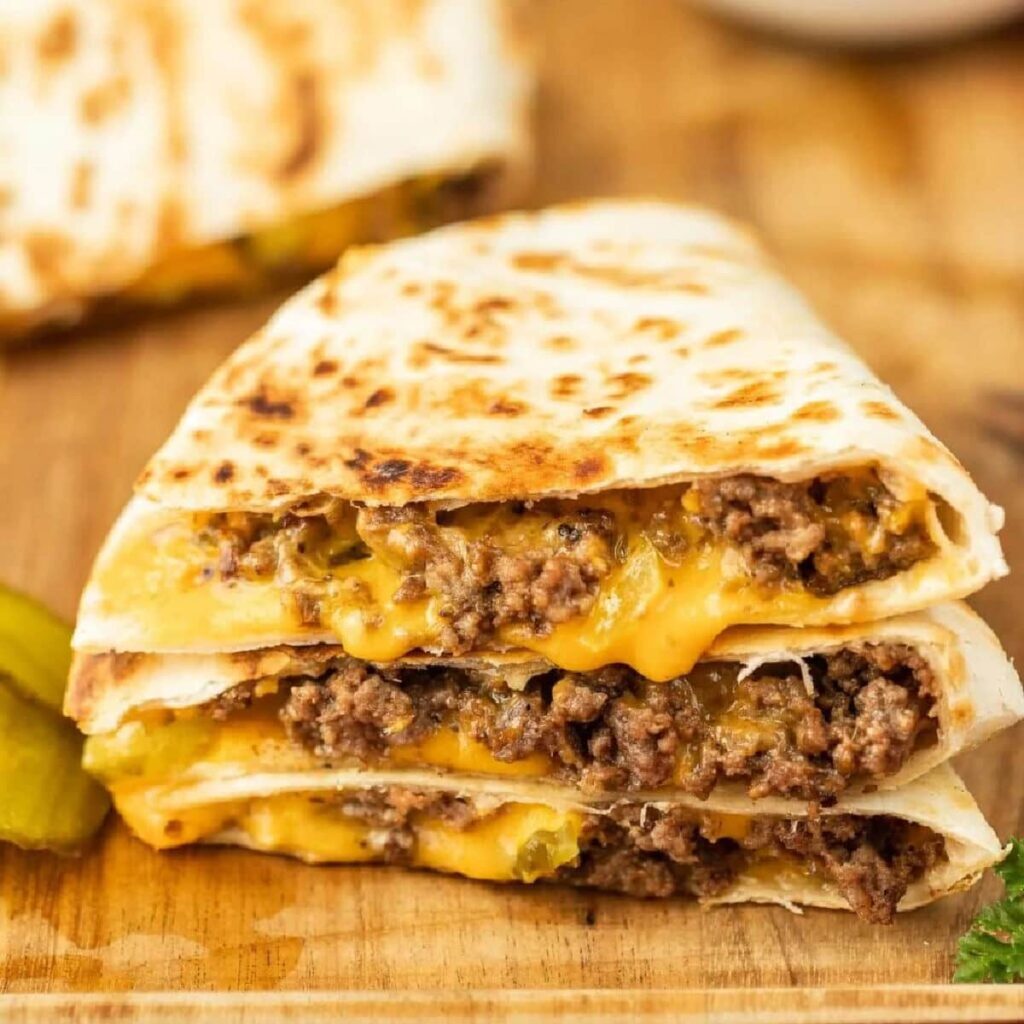 Cut the tortilla in half and add one burger to each half