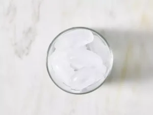 Fill an old-fashioned glass with ice.