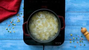 For the potatoes, I put them in a big pot, cover with water, and bring it to a boil. Then I lower it and let them simmer until fork tender, about 10 to 15 minutes. I drain them, put them back in the hot pot, and let them sit for a minute to dry out.