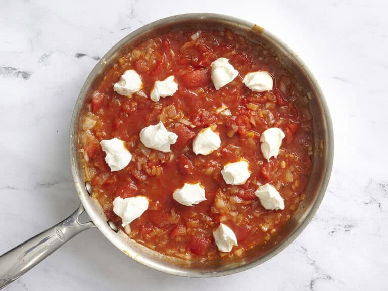 Lower the heat and add the cream cheese in small pieces. Whisk until the sauce becomes smooth and creamy. Stir in the Parmesan until melted.
