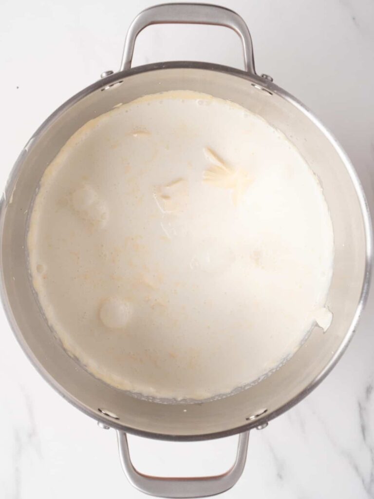 Pour in the chilled heavy cream and whip until the mixture becomes light, fluffy, and holds soft peaks. Stop once it looks smooth and spreadable.