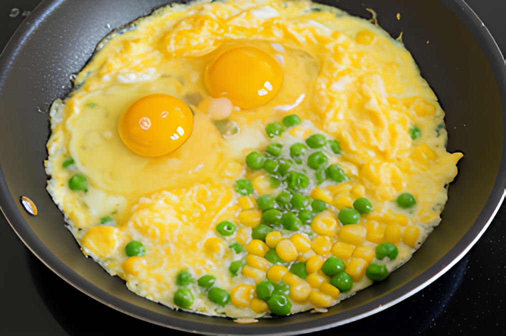 Push the vegetables to one side of the skillet. Pour the beaten eggs into the empty side and scramble them gently until just set (1)