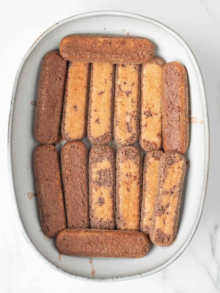 Quickly dunk each ladyfinger into the espresso mixture. One to two seconds is plenty. Line the bottom of a 7x11 oval baking dish with the soaked cookies.