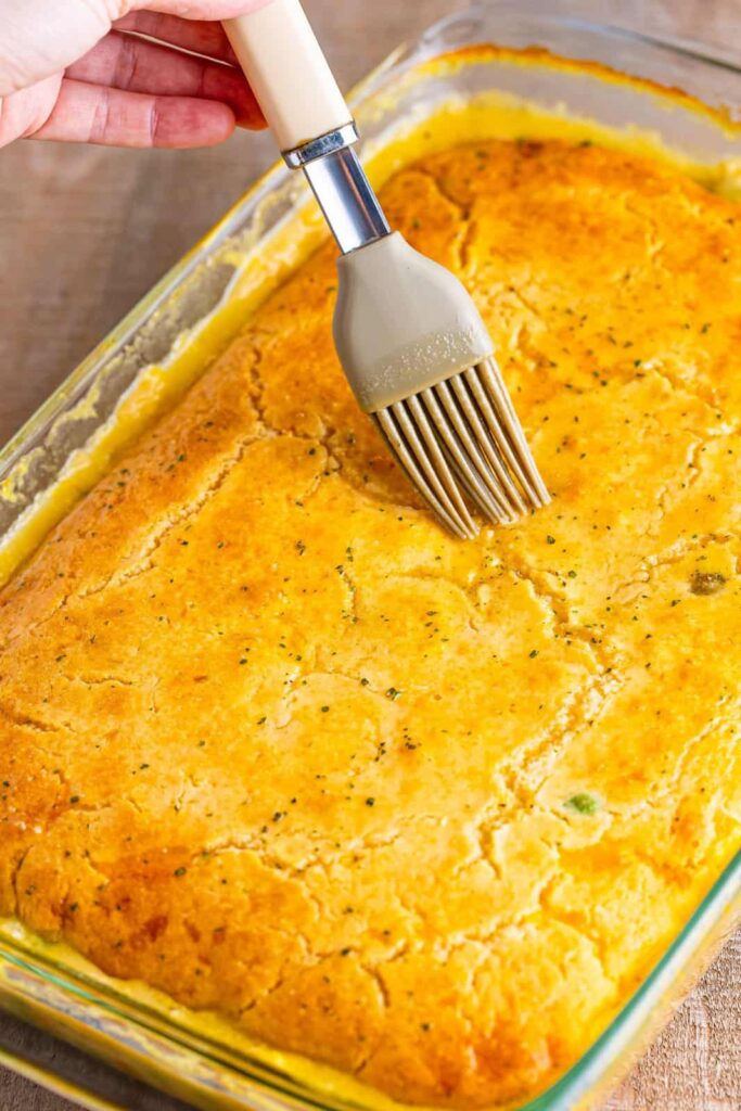 Remove the cobbler from the oven and brush the butter mixture over the top of the crust