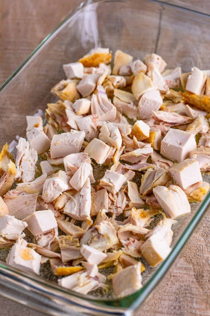 Spread the chopped rotisserie chicken evenly over the melted butter. Do not stir