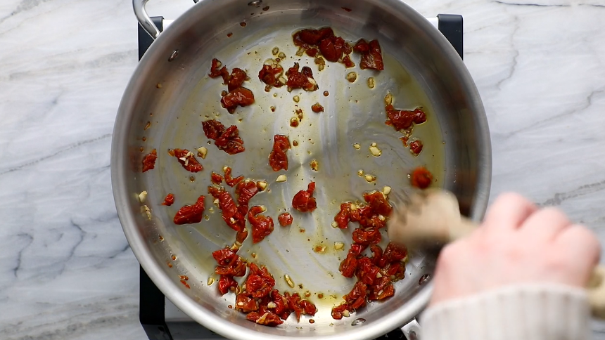Heat a skillet over medium heat and use a small amount of oil from the sun-dried tomatoes to sauté the garlic and sun-dried tomatoes until soft and fragrant, approximately 2-3 minutes.