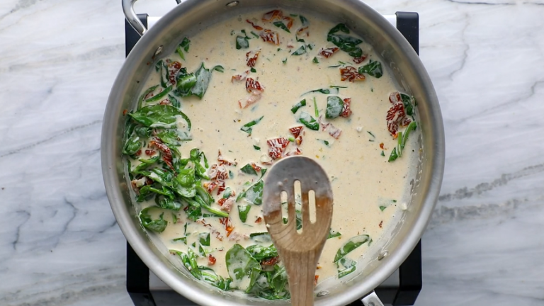 Incorporate the heavy cream and chopped spinach, bringing the mixture to a simmer. Season with salt and pepper.