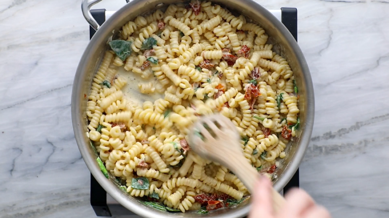 Stir in the cooked pasta, adjusting the sauce consistency with reserved pasta water as needed.