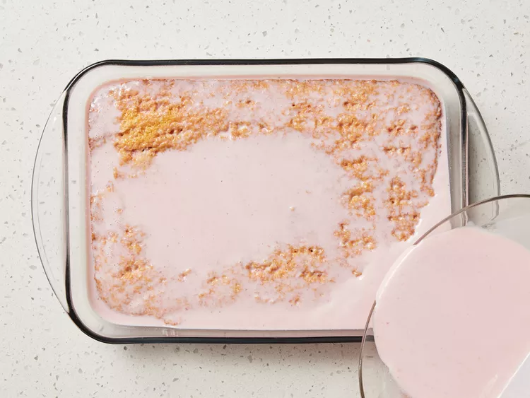 Poke holes all over the cooled cake and slowly pour the strawberry milk mixture evenly on top