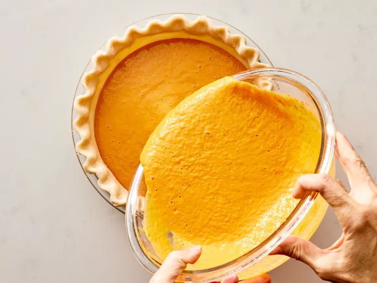 For the filling, I dump the pumpkin, evaporated milk, brown sugar, beaten eggs, cinnamon, ginger, nutmeg, and salt into a bowl. I mix it all together until it looks smooth and smells incredible. Then I pour it straight into the crust.