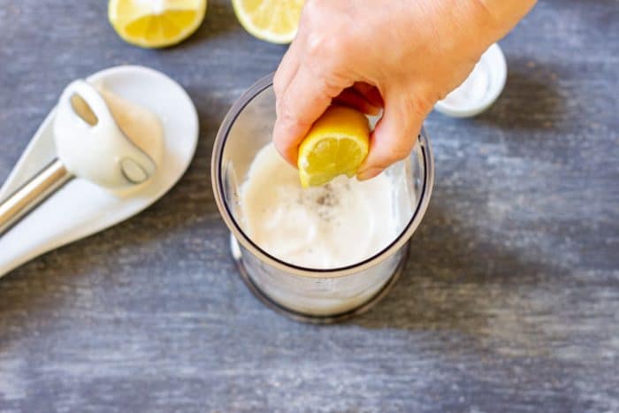 Once the aioli reaches a thick, creamy consistency, blend in lemon juice and a pinch of salt