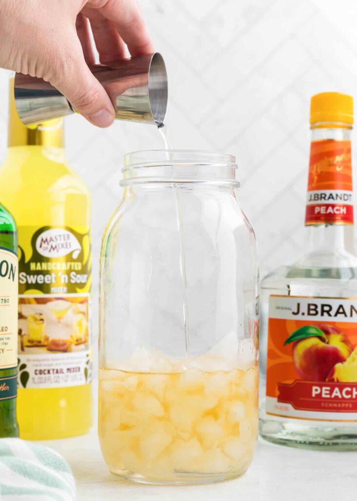 Pour in equal parts whiskey, peach schnapps, and sweet and sour mix