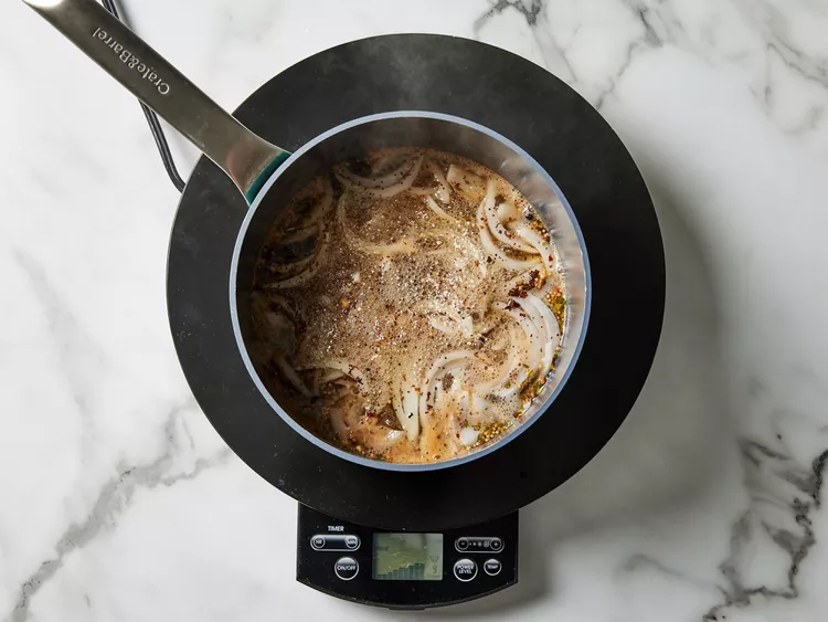 In a saucepan, combine vinegar, water, most of the onion slices, salt, pickling spice, and peppercorns. Bring to a rolling boil