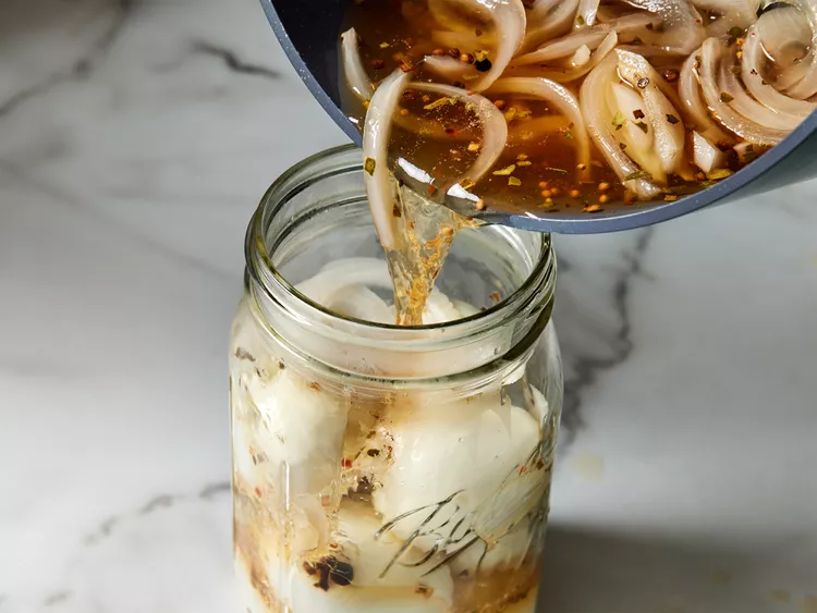 Carefully pour the hot brine over the eggs in the jar. Top with the remaining onion slices.