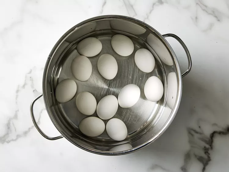 Place the eggs in a large pot and cover them with cold water. Bring to a boil, then remove from heat, cover, and let sit.
