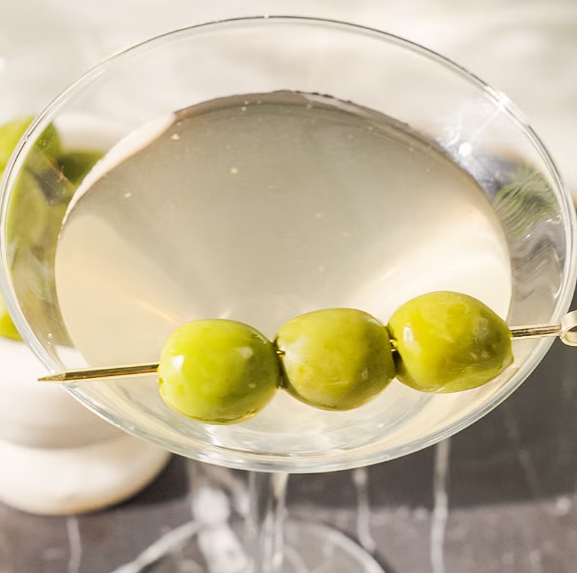 Skewer olives and drop them into the glass.