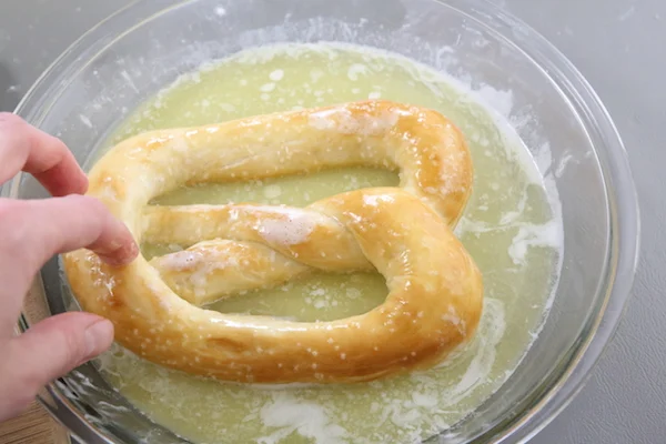 Immediately dip warm pretzels into melted butter. Serve warm