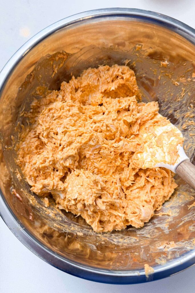 In a large bowl, stir together shredded chicken, buffalo sauce, cream cheese, garlic powder, paprika, ½ teaspoon salt, and black pepper until evenly combined