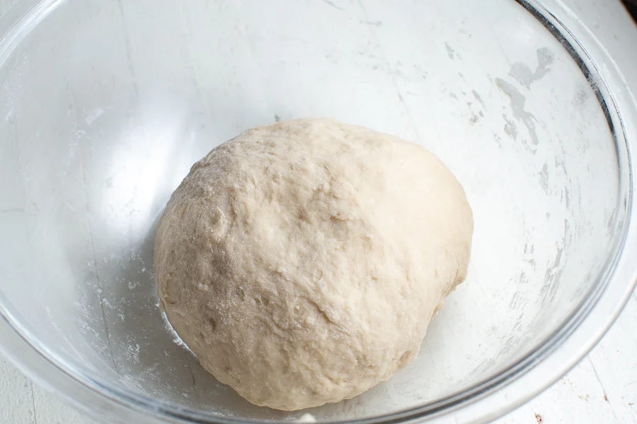 Pour in the yeast mixture and knead until the dough forms a slightly tacky ball