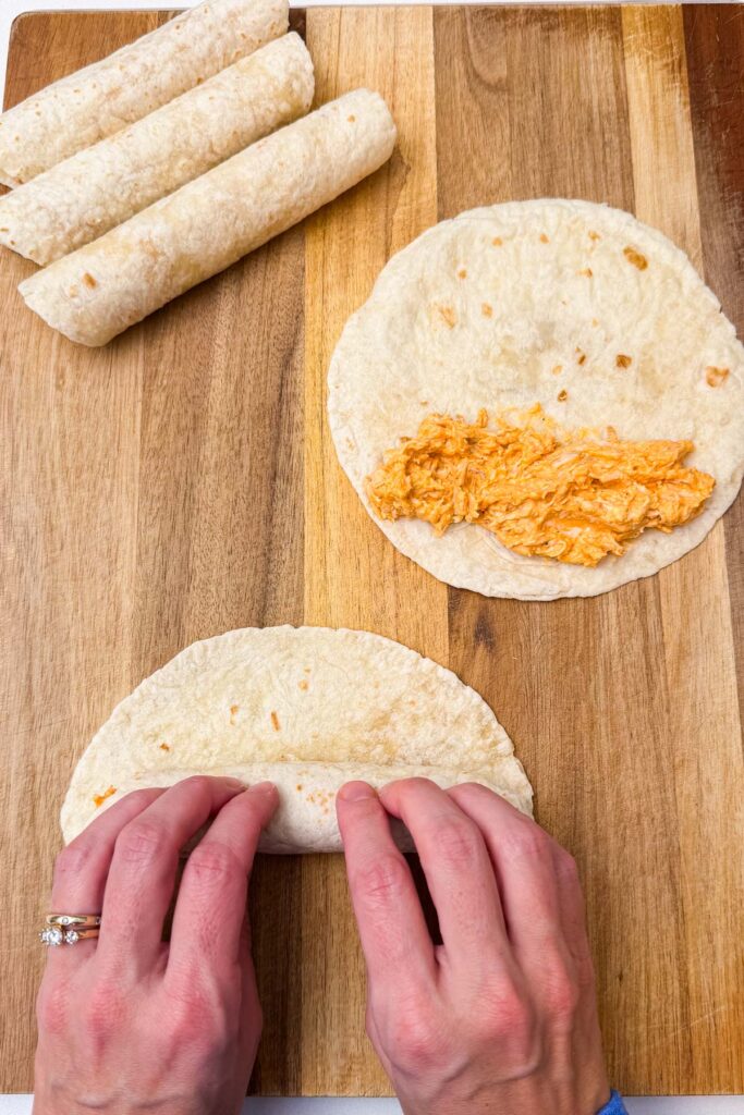 Spoon about ¼ cup of the chicken mixture onto one end of each tortilla. Roll tightly into a taquito and place seam-side down on the prepared baking sheet