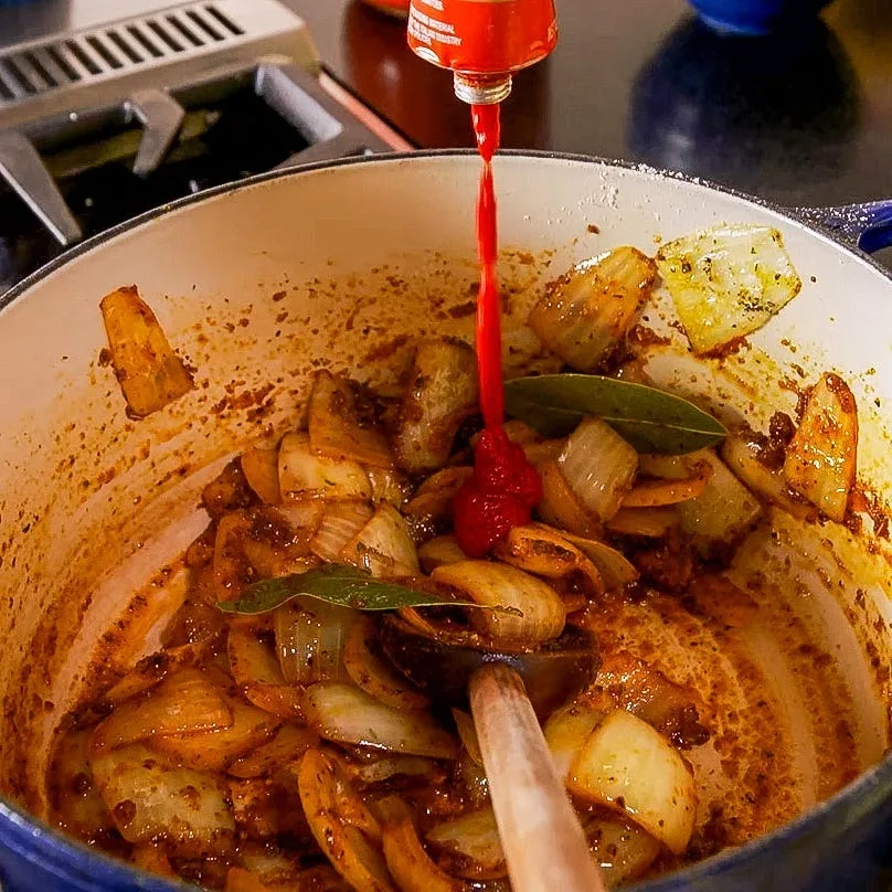 Add the bay leaves, curry powder, paprika, thyme, ginger, garlic powder, onion powder, and black pepper. Cook for about 1 minute to bloom the spices.