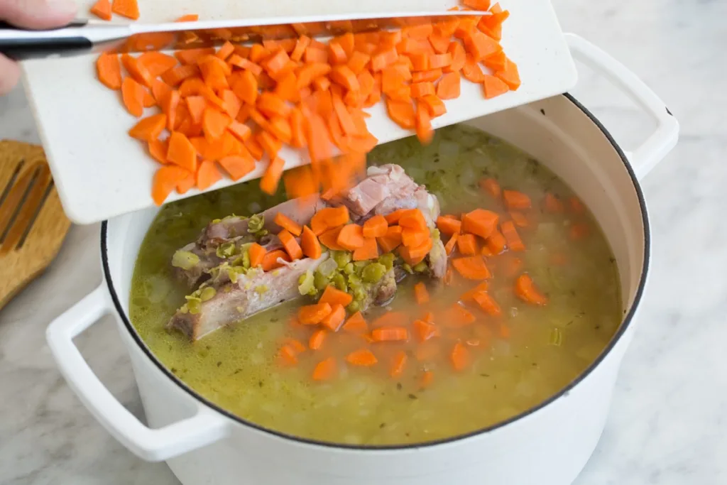 Add the chopped carrots to the soup. Cover and continue simmering for about 30 more minutes, stirring occasionally, until the peas have mostly broken down and the soup has thickened.