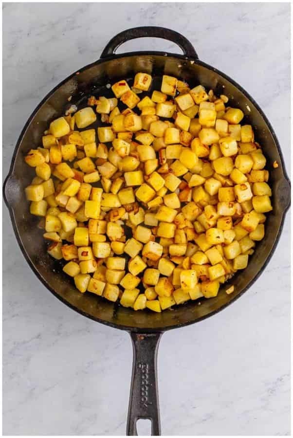 Add the cooked potatoes and diced onion along with salt and pepper, cooking while stirring occasionally until the onions soften and the potatoes begin to develop golden edges