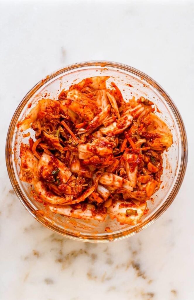 Add the drained cabbage to the prepared paste and gently mix by hand until every leaf is evenly coated