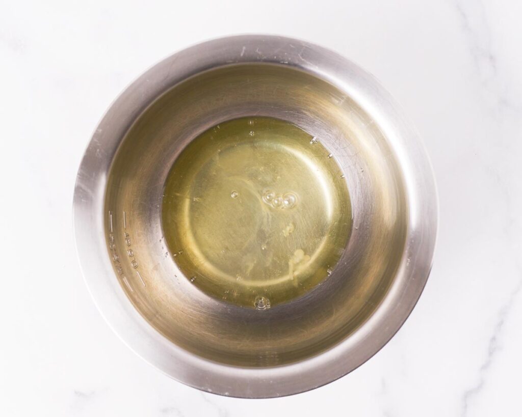 Add vinegar or lemon juice to the egg whites and beat until frothy