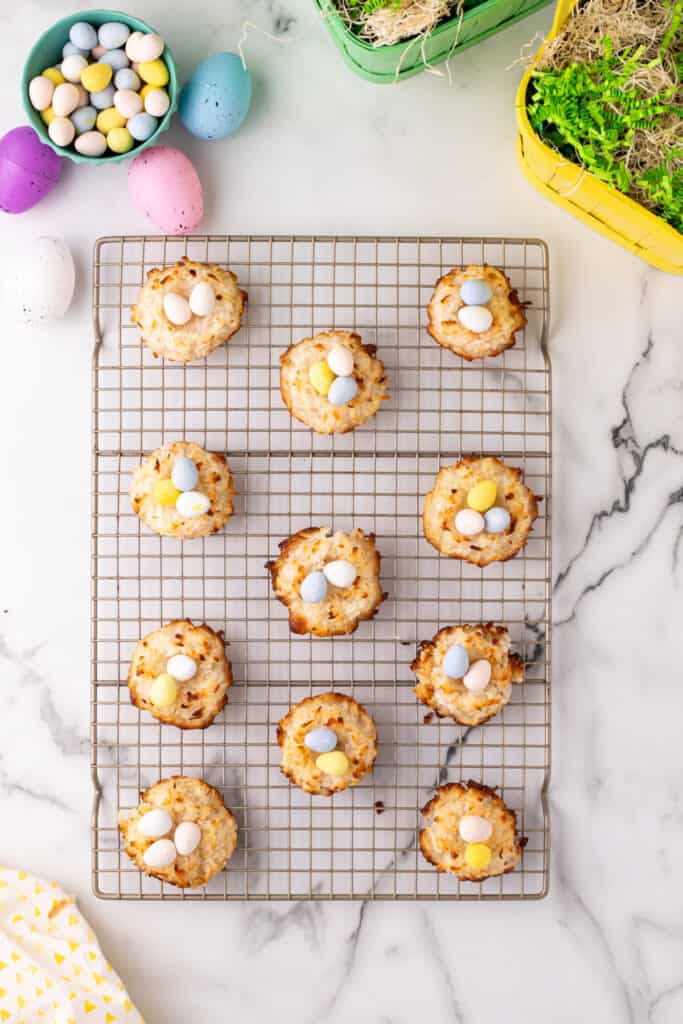Allow the macaroons to cool completely, then place candy eggs into the center of each nest