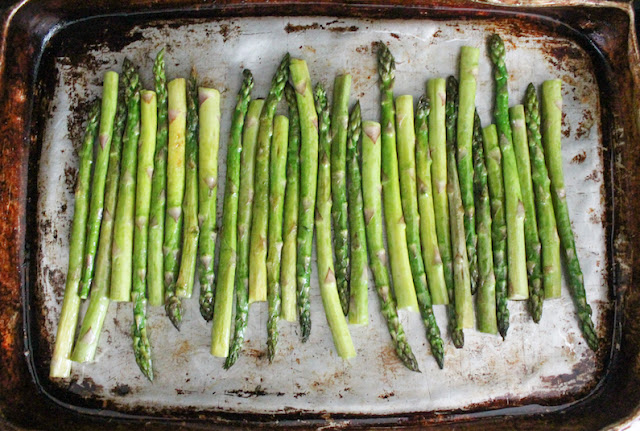 Arrange the asparagus in a single layer on a baking sheet. Drizzle lightly with olive oil and season with salt and pepper