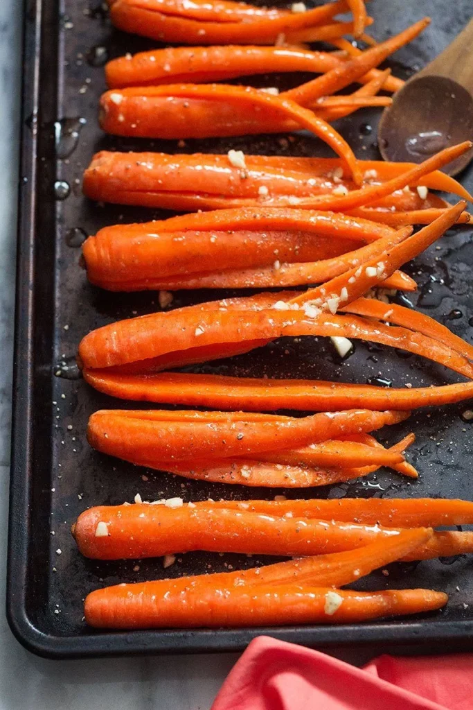 Arrange the carrots on the baking sheet in a single layer and coat them thoroughly with the honey garlic butter mixture