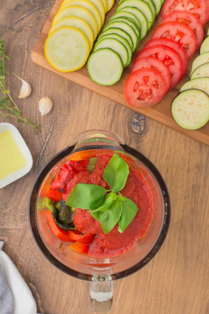 Combine the softened vegetables, peeled peppers, crushed tomatoes, basil, herbs, salt, and pepper in a blender and puree until smooth