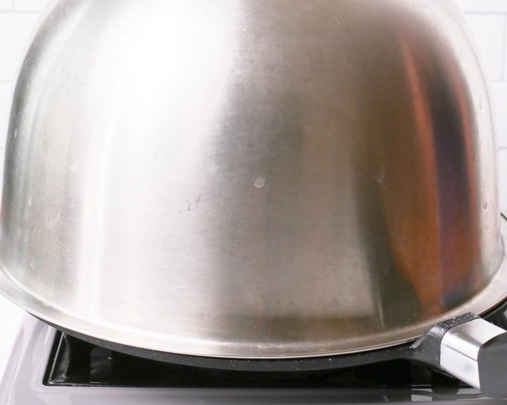 Cover the pan with a lid and cook until the bottom is golden brown and the pancakes have set enough to flip