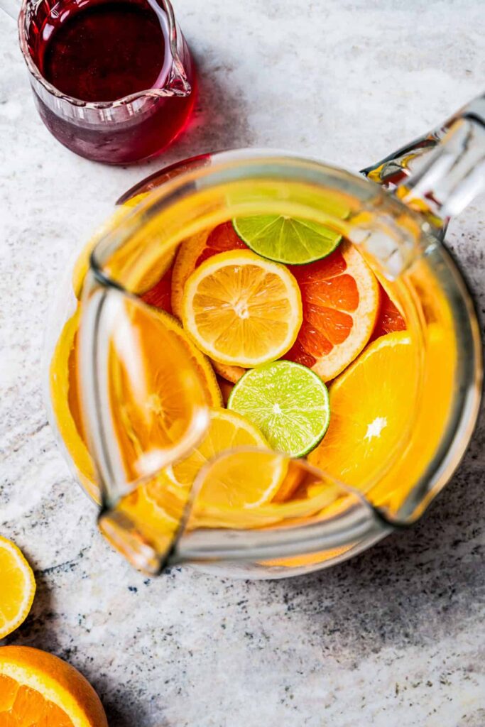 Fill a large pitcher with sliced citrus fruits to create a colorful base