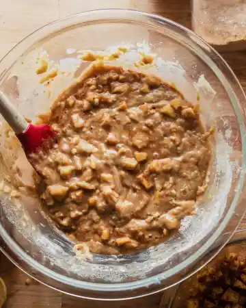 Fold most of the apple mixture into the batter, reserving a portion for the topping. Transfer the batter into the prepared loaf pan and spread evenly
