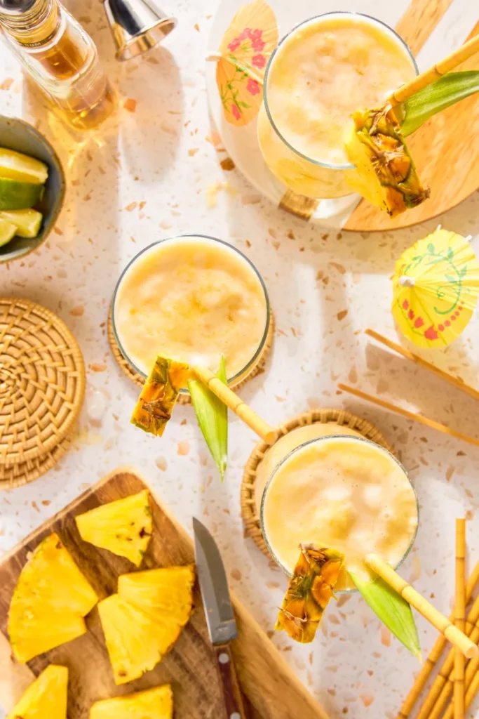 Garnish with pineapple leaves or wedges if desired and serve immediately while cold and frothy