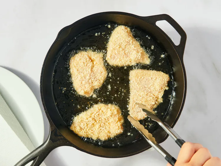 Heat oil in a skillet over medium heat. Add the chilled chicken pieces carefully and cook until golden brown on one side