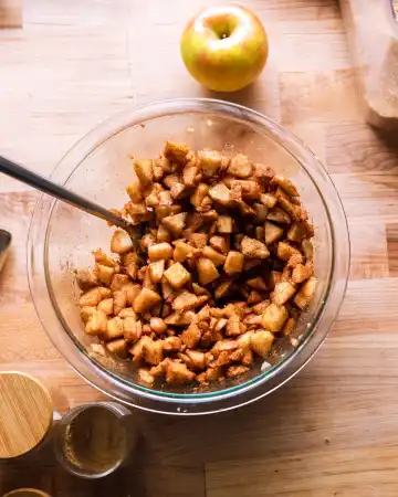 In a medium bowl, combine the chopped apples with brown sugar, cinnamon, and ginger. Mix well and set aside so the flavors can blend