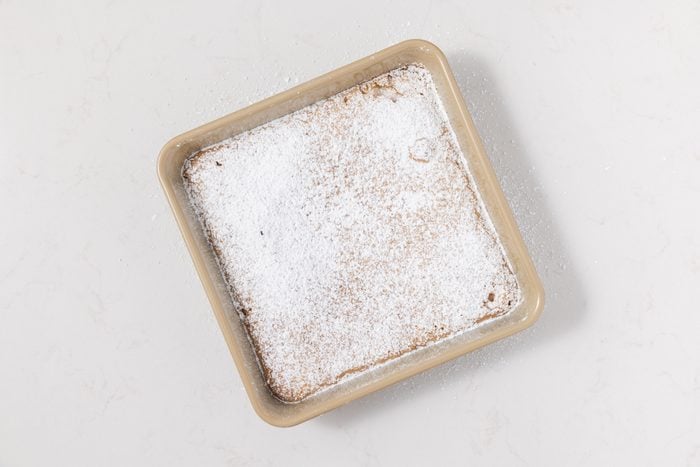 Once cooled, dust generously with confectioners’ sugar and cut into squares before serving