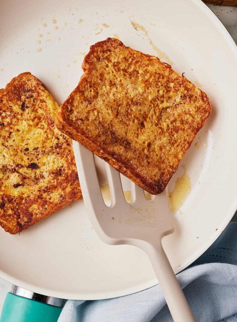 Place the coated bread slices onto the hot skillet and cook until the underside becomes golden brown, then flip and cook the other side until evenly browned and cooked through