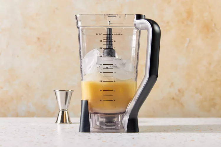 Place the white rum, cream of coconut, pineapple juice, frozen pineapple chunks, and ice into a blender