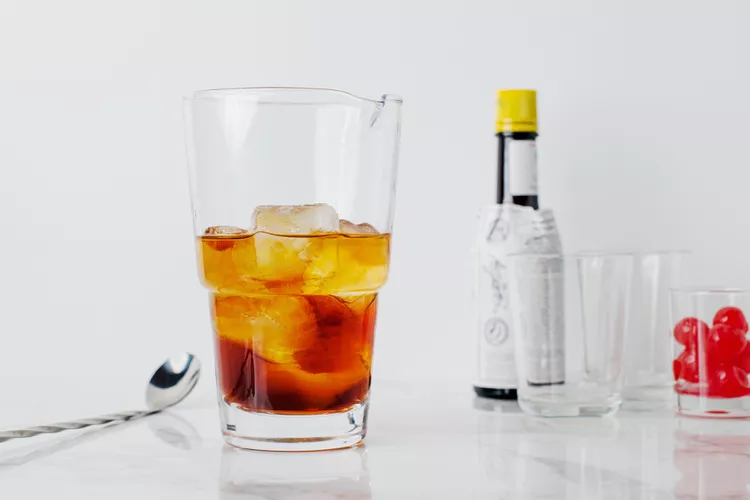 Pour the whiskey, sweet vermouth, and aromatic bitters over the ice
